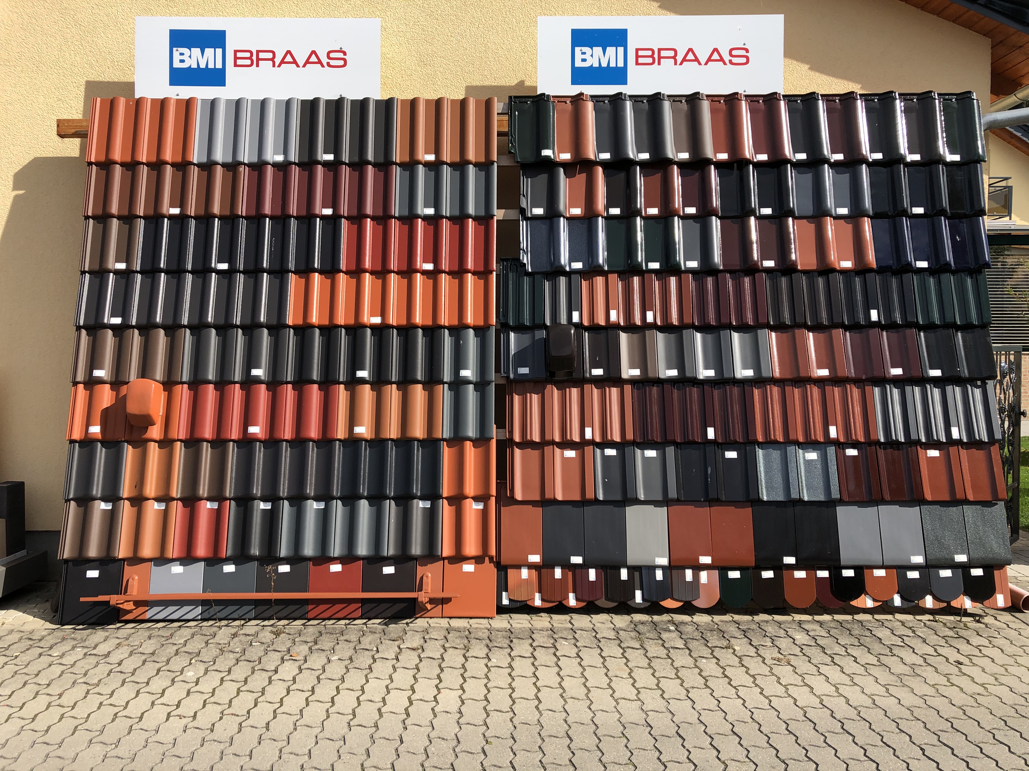 Ausstellung von farbenfrohen Dachziegeln der Marke BMI Braas an einer Außenwand